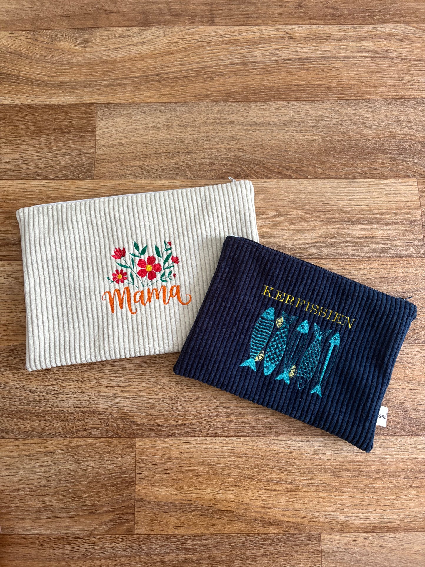 Deux pochettes plates en velours côtelé, tailles M et L, posées côte à côte, en version sur-mesure personnalisable.