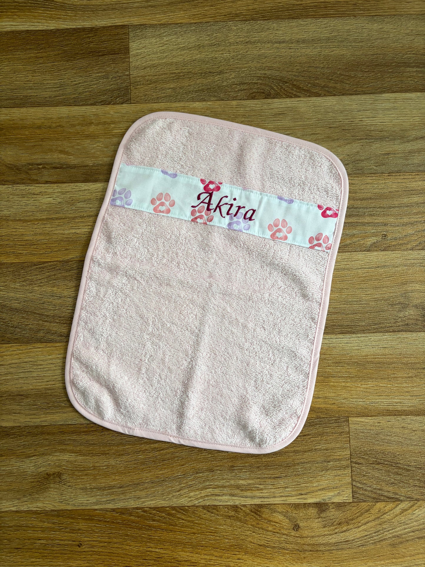 Petite serviette pour animal rose personnalisée avec bande à motifs pattes et prénom Akira brodé