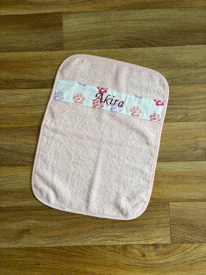 Petite serviette pour animal rose personnalisée avec bande à motifs pattes et prénom Akira brodé